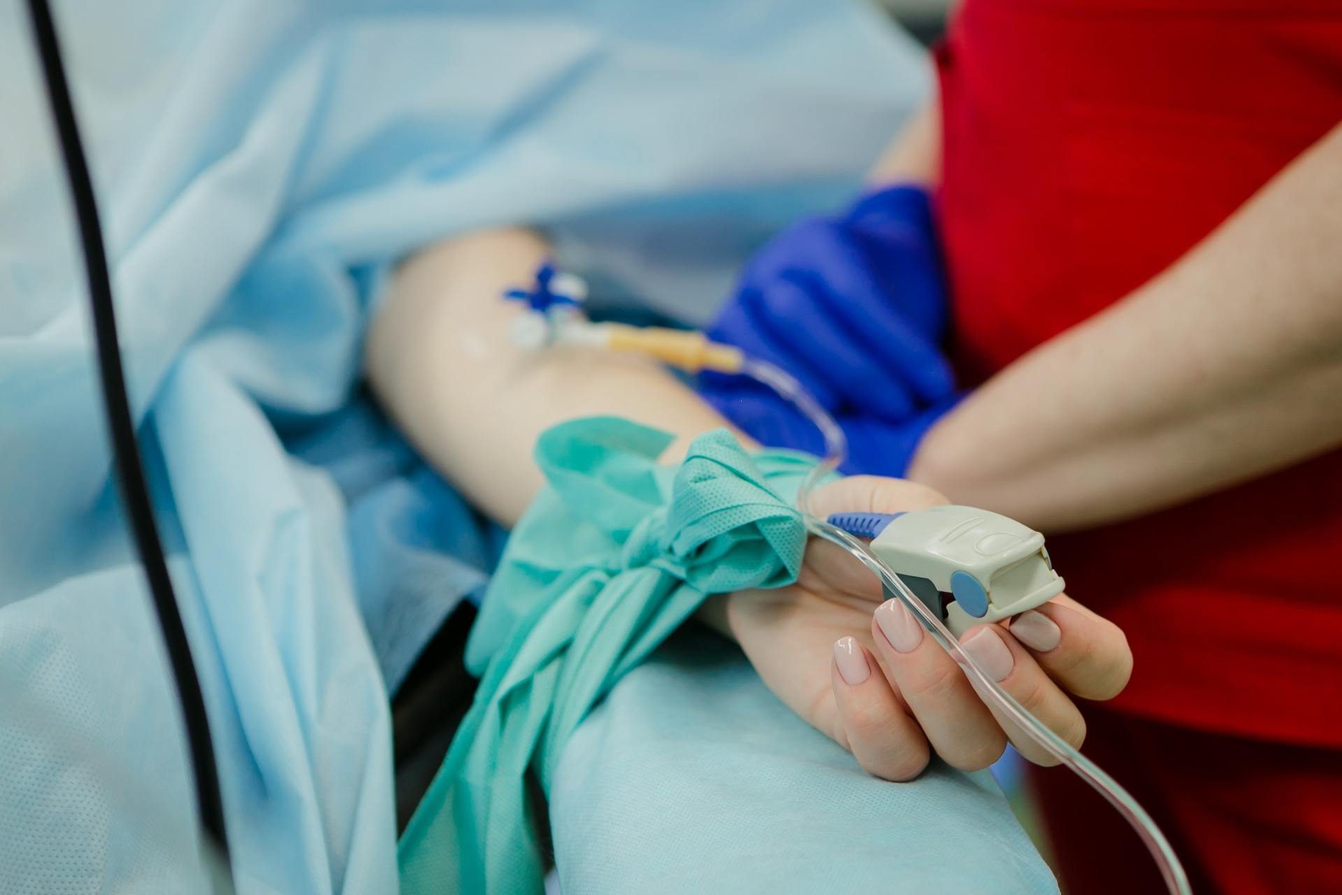 Untersuchung an der Hand einer Patientin unter sterilem Tuch